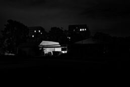 Schwarzweiß-Fotografie, Thema: Stadt: Häuser mit Lichtquellen bei Nacht